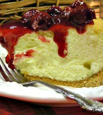 Tall New York Cheesecake on a white plate with a fork