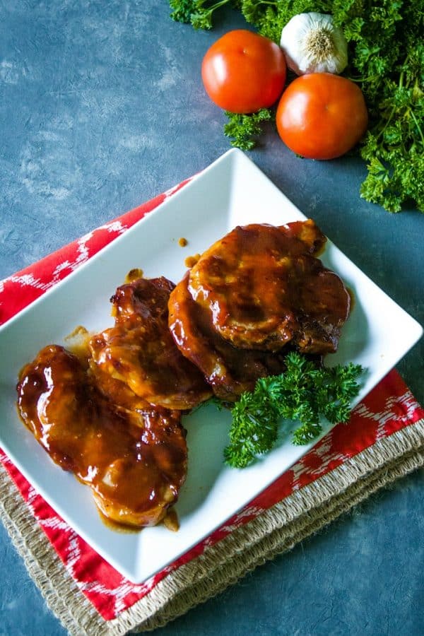 Barbecue Sauce covered pork chops on a white platter