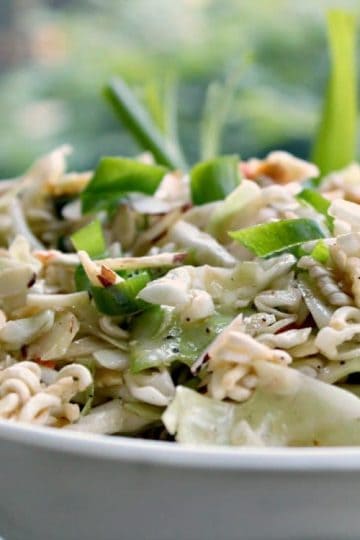 Amazing Asian Coleslaw is a crunchy blend of cabbage, ramen and onions topped with a sweet and sour sesame dressing. This flavorful salad will be a hit at any barbecue, potluck or picnic!