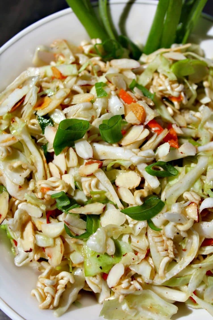 Amazing Asian Coleslaw is a crunchy blend of cabbage, ramen and onions topped with a sweet and sour sesame dressing. This flavorful salad will be a hit at any barbecue, potluck or picnic!
