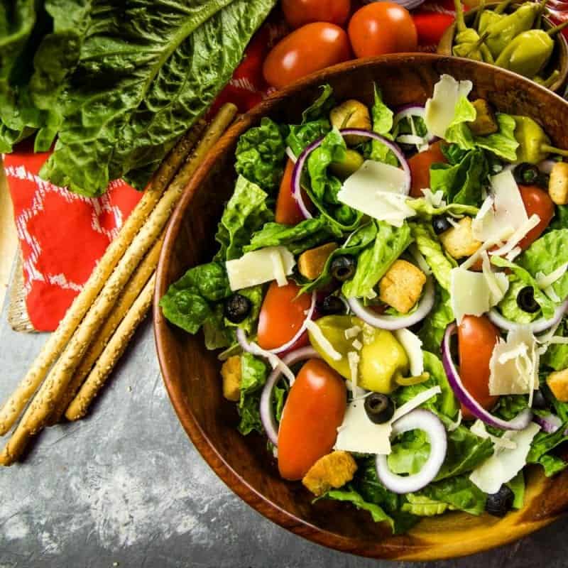 Copycat Olive Garden Salad is a true take on the original recipe with fresh lettuce greens, roma tomatoes and pepperoncini peppers. Served family style, just like the restaurant!