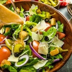 Copycat Olive Garden Salad is a true take on the original recipe with fresh lettuce greens, roma tomatoes and pepperoncini peppers. Served family style, just like the restaurant!