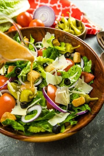 Copycat Olive Garden Salad is a true take on the original recipe with fresh lettuce greens, roma tomatoes and pepperoncini peppers. Served family style, just like the restaurant!