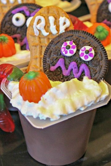Gremlins in the Graveyard are chocolate pudding cups decorated with a froth of whipped cream, scary cookies and Halloween candy! A great party treat or a snack before the kids head out for Beggars Night!