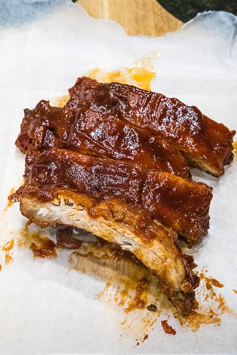 Best Ever Oven BBQ Ribs are moist, fall off the bone pork, smothered in a crispy, caramelized BBQ sauce. #mustlovehomecooking