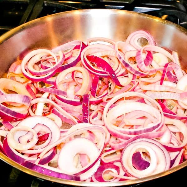 sliced red onions in skillet