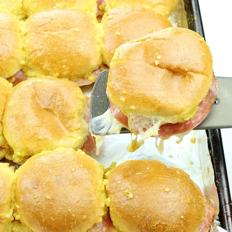 Italian Ham and Cheese Sliders - hot and tangy little sandwiches that are big on flavor.  Savory ham, spicy salami, velvety swiss cheese and a zippy mustard sauce combine to make an irresistible snack or a meal that everyone will love!