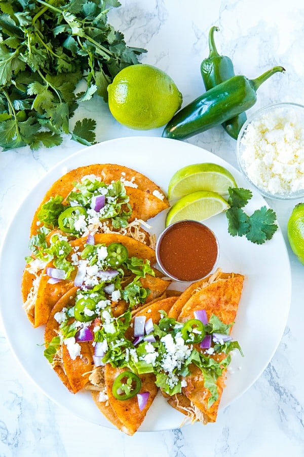 Chicken Street Enchiladas are corn tortillas dipped in thick enchilada sauce then filled with chicken and queso fresco, served folded over like a taco. Easy to make and fun to eat. #mustlovehomecooking #streetenchilada #mexicanfood