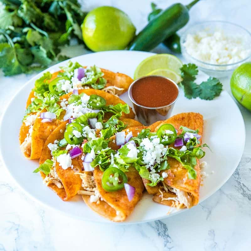 Chicken Street Enchiladas are corn tortillas dipped in thick enchilada sauce then filled with chicken and queso fresco, served folded over like a taco. Easy to make and fun to eat. #mustlovehomecooking #streetenchilada #mexicanfood