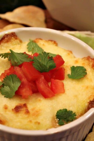 Tequila Queso Fundido is melted cheese flavored with tomatoes, chiles, onion and a splash of tequila - perfect with tortilla chips or served in warmed tortillas for your next party!