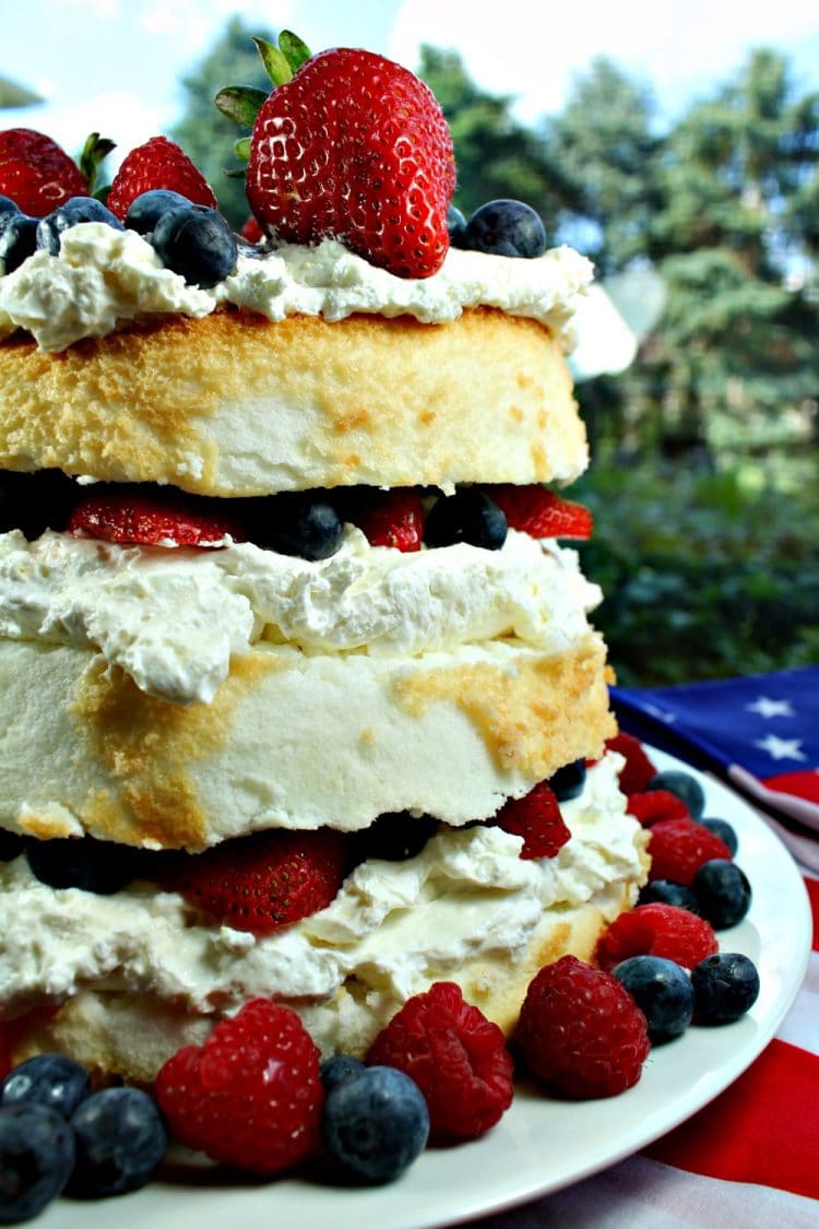 Patriotic Angel Food Cake is layers of fluffy cake, stuffed with a cream cheese filling and then fruit mounded in the layers and on top. A perfect summer dessert!