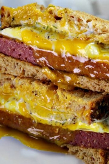 A Buckeye Breakfast Sandwich is a thick slab of Lebanon Bologna, aged cheddar cheese, and a fried egg served on toasted wheat bread that has been slathered with dill mayonnaise - a tasty family favorite and quick recipe that takes less than 10 minutes!