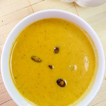 Harvest Pumpkin Soup is a creamy blend of pumpkin, broth and cream served warm with pistachios sprinkled on top