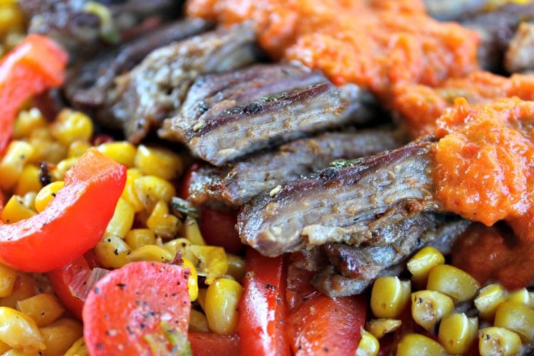 Skirt Steak with Red Pepper Puree is marinated then pan fried skirt steak drenched in a smooth and flavorful red pepper puree. Served with pan fried peppers, corn and red onion.