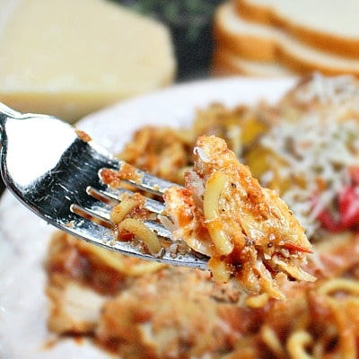 Easy Slow Cooker Tuscan Chicken is tender chicken, seasoned with peppers and Italian herbs, served on a bed of pasta!