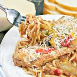 Easy Slow Cooker Tuscan Chicken is tender chicken, seasoned with peppers and Italian herbs, served on a bed of pasta!