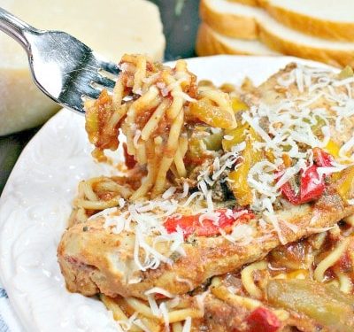 Easy Slow Cooker Tuscan Chicken is tender chicken, seasoned with peppers and Italian herbs, served on a bed of pasta!