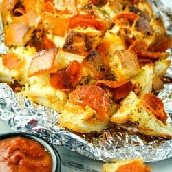 Pepperoni Pizza Pull Apart Bread is made with layers of melting cheese, spicy pepperoni and a Dijon butter glaze. Great for parties, snacking or anytime! #mustlovehomecooking