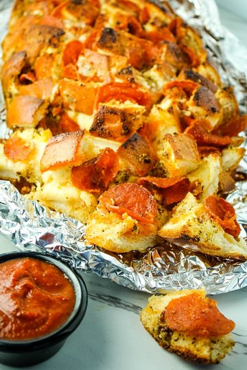 Pepperoni Pizza Pull Apart Bread is made with layers of melting cheese, spicy pepperoni and a Dijon butter glaze. Great for parties, snacking or anytime! #mustlovehomecooking