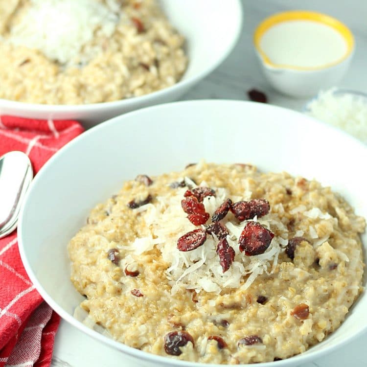 This hearty Slow Cooker Cranberry Coconut Oatmeal is made with lots of creamy coconut milk, steel cut oats, chewy dried cranberries, brown sugar and pie spice. Top off each bowlful with a handful of cranberries and coconut followed by a splash of coconut milk. A true breakfast of champions!