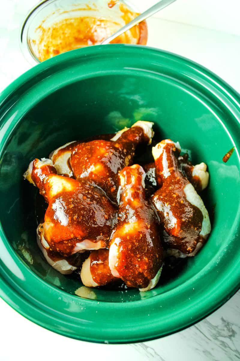 chicken spread with barbeque sauce in green slow cooker insert