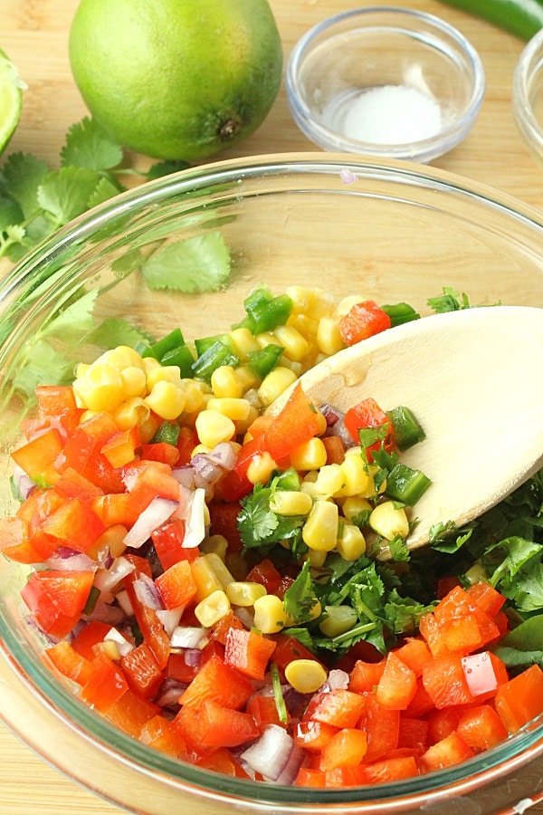 corn red pepper salsa in mixing bowl with spoon