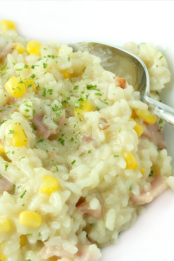 creamy ham and corn risotto on plate with spoon