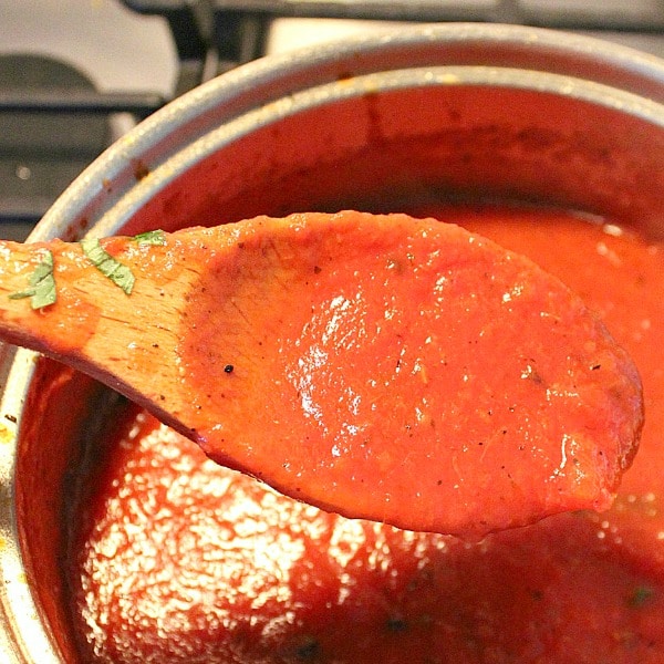 homemade marinara sauce in a saucepan with wooden spoon
