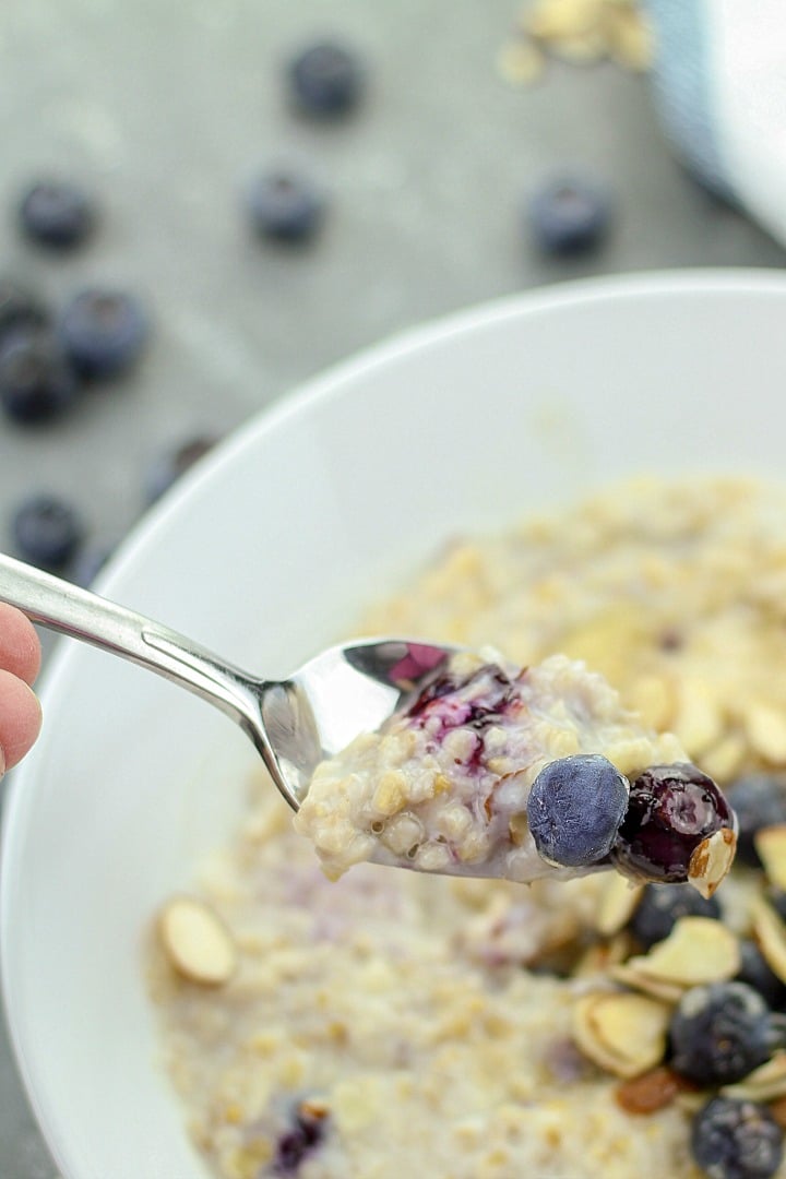 Slow Cooker Blueberry Almond Oatmeal, a super healthy breakfast made with milk, steel cut oats, fresh blueberries, honey and cinnamon. Kid tested goodness!