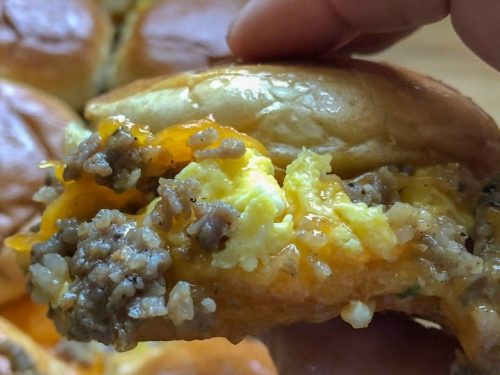 egg sausage breakfast slider held in hand
