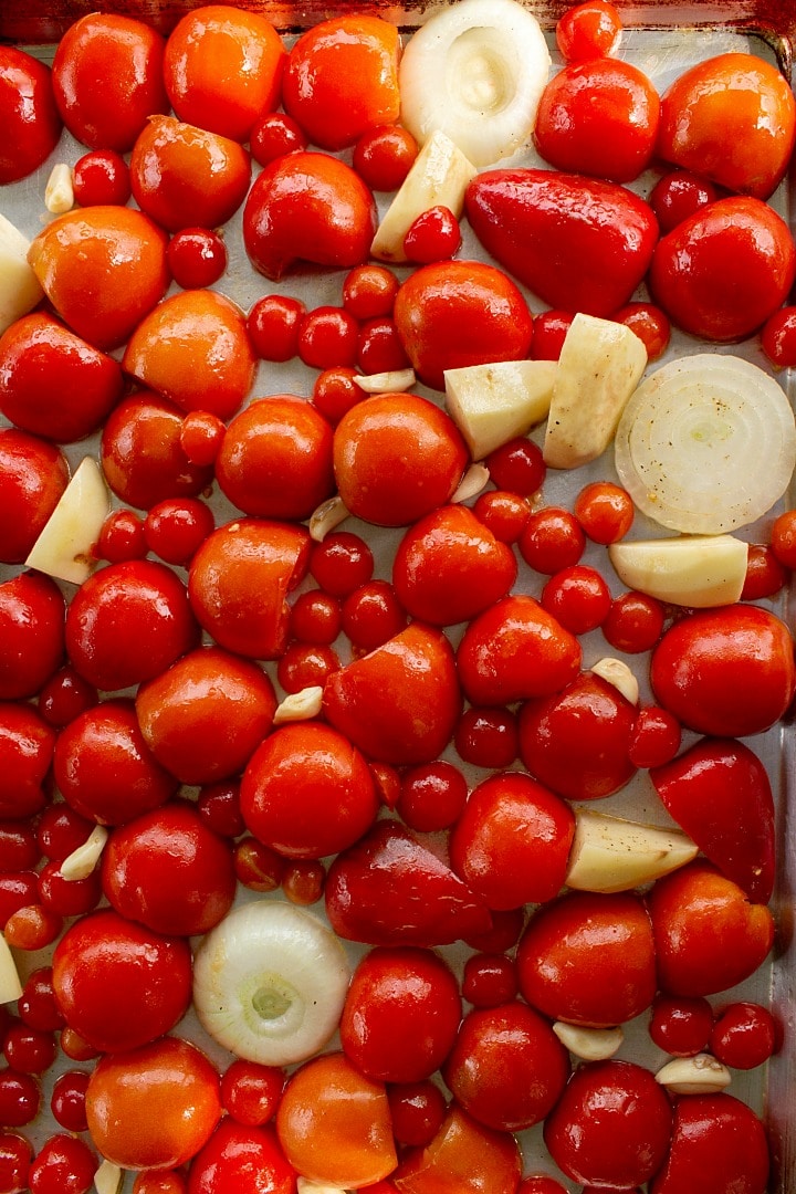 tomatoes and vegetables on sheet pan ready for roasting