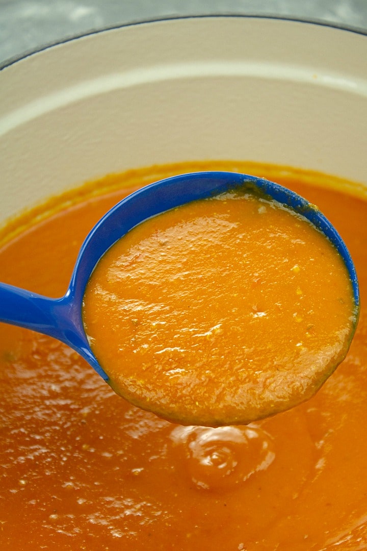 roasted tomato soup on blue ladle