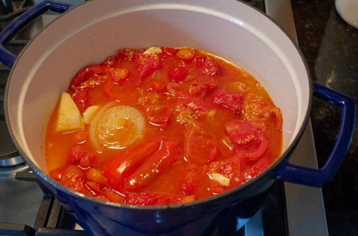 fresh roasted tomato soup in blue pot ready for cooking on stove