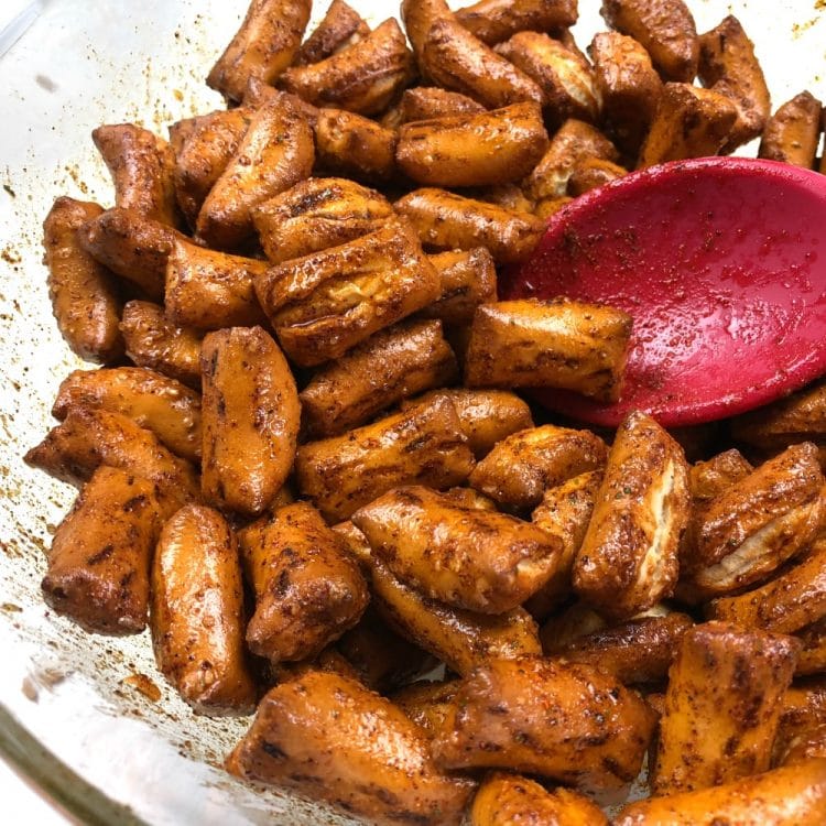 Zesty Ranch Pretzels stirred with a red silicone spoon