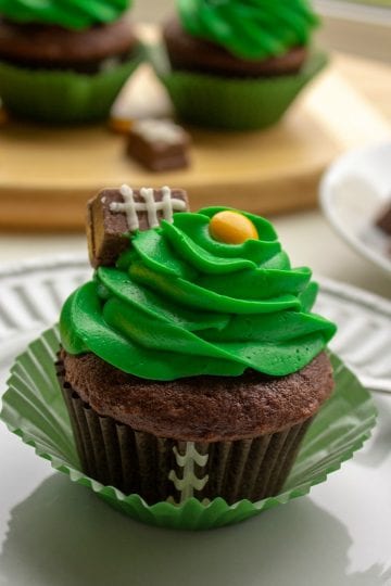 Easy Candy Football Cupcakes are chocolate cake, topped with rich buttercream frosting. Decorated with candies, these cupcakes are perfect for game day parties and tailgating!