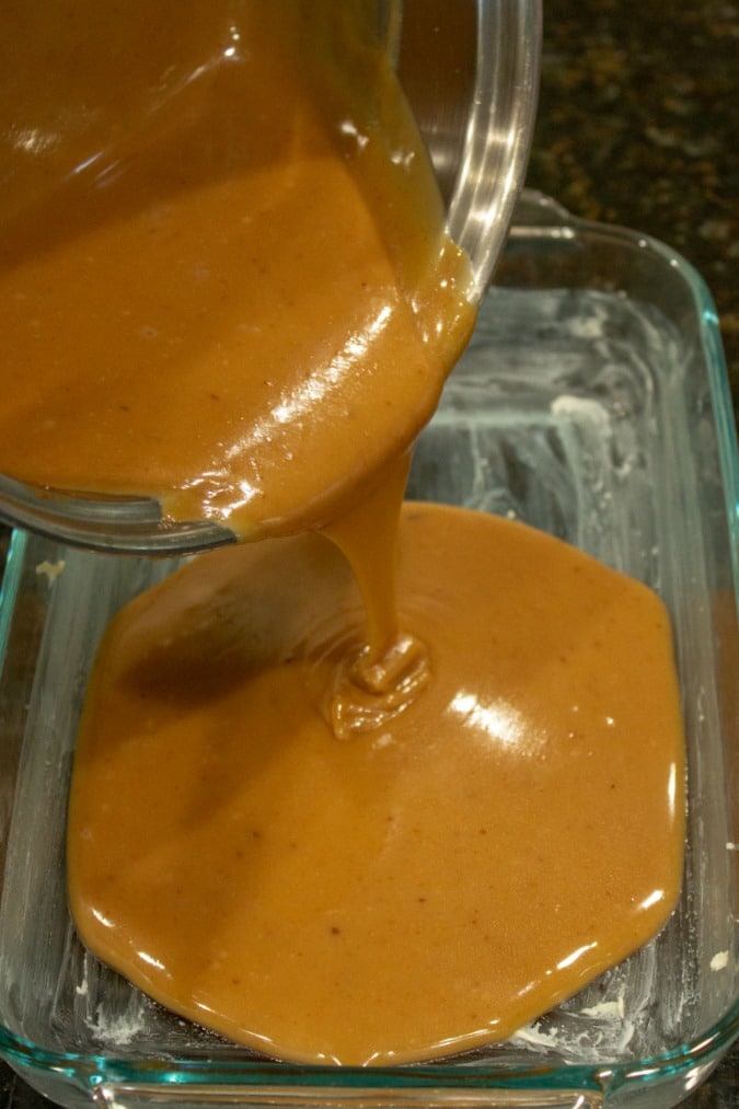 Easy Salted Caramels mixture being poured into glass pan to harden.