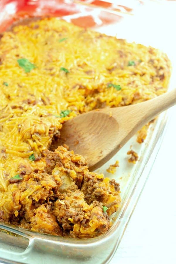 Taco Biscuit Casserole being served with wooden spoon