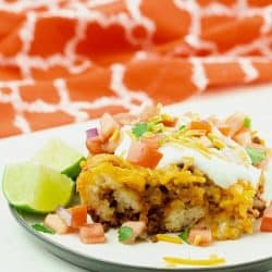 Taco Biscuit Casserole served on white plate with sour cream and pico de gallo