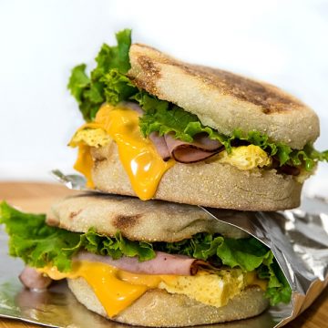 Easy make ahead freezer breakfast sandwiches are ready for a start the day meal on-the-go. Prep a batch with herb seasoned eggs, ham and sliced cheese in under 25 minutes!