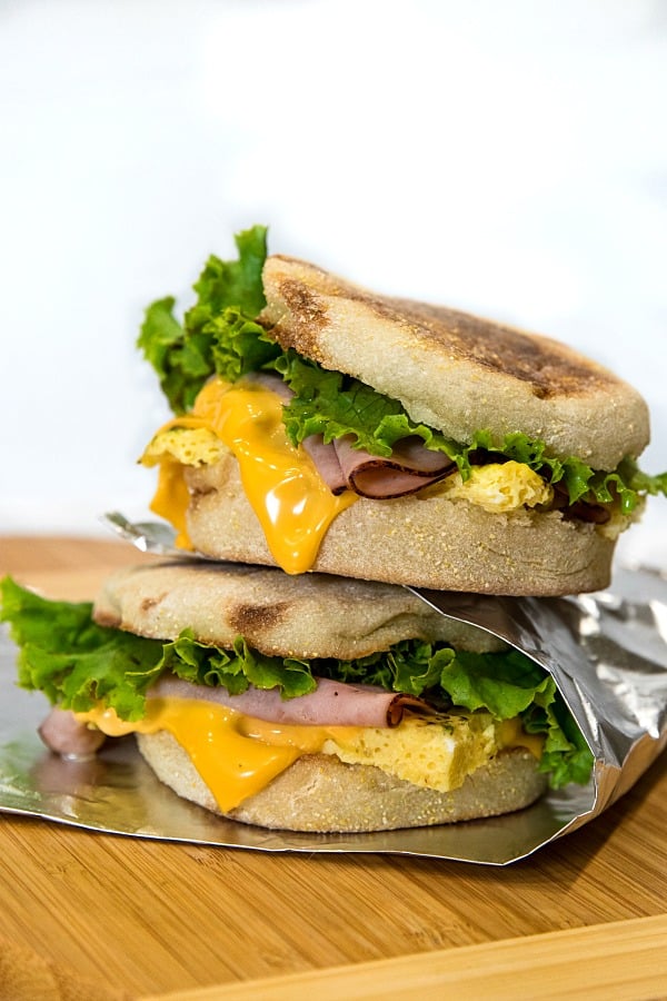 Easy make ahead freezer breakfast sandwiches are ready for a start the day meal on-the-go. Prep a batch with herb seasoned eggs, ham and sliced cheese in under 25 minutes!
