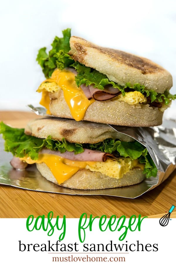 Easy make ahead freezer breakfast sandwiches are ready for a start the day meal on-the-go. Prep a batch with herb seasoned eggs, ham and sliced cheese in under 25 minutes! #mustlovehomecooking
