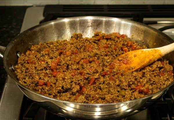 Ground beef with tomatoes and chilies cooking in skillet