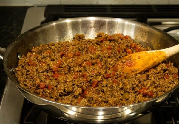 Ground beef with tomatoes and chilies cooking in skillet