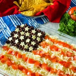 Patriotic Layered Party Dip is a huge hit at any summer party. Layer taco sour cream, beans, cheese and tomatoes for a quick, zesty dip!