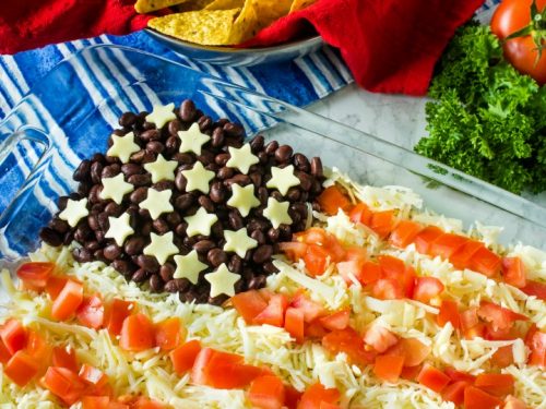 Patriotic Layered Party Dip is a huge hit at any summer party. Layer taco sour cream, beans, cheese and tomatoes for a quick, zesty dip!