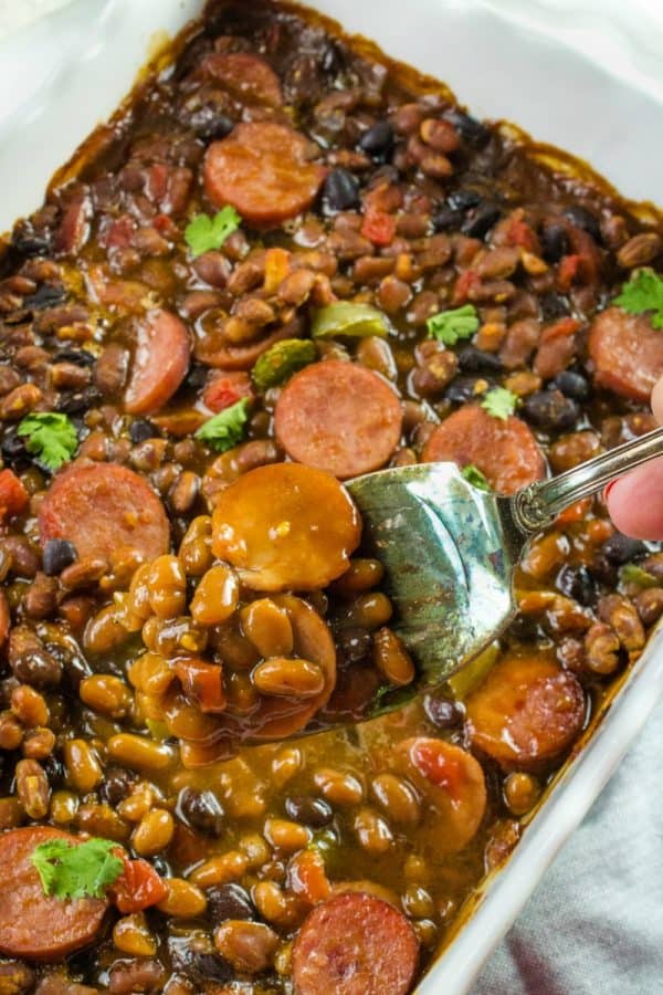 Smoked sausage, canned baked and black beans, tomatoes with green chilies and green bell pepper make an easy weeknight dinner with a sweet and spicy sauce.