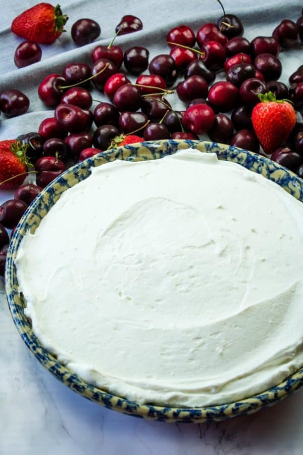 cheesecake base spread out in pan, waiting for cherry topping.