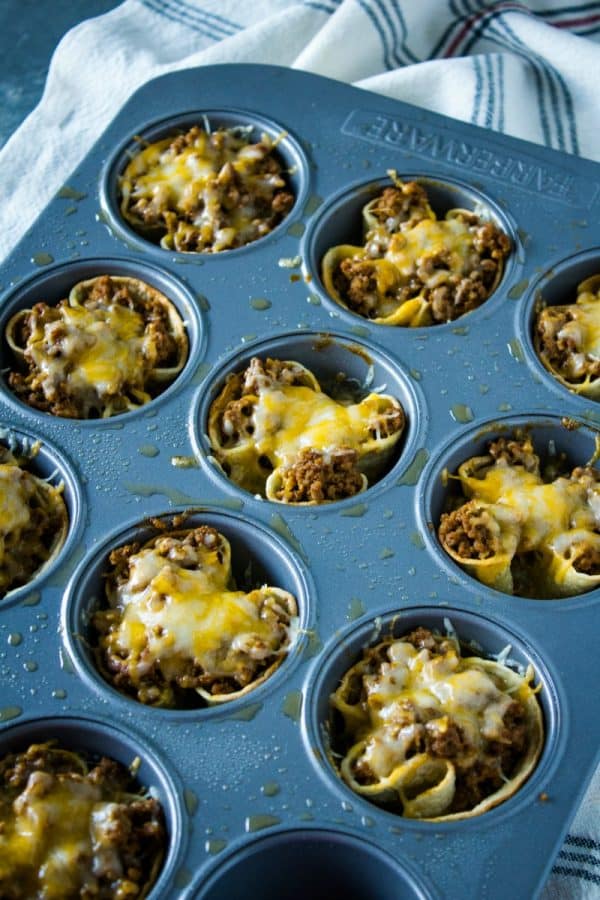 Tortilla taco cups are fun appetizers and a tasty twist on taco night. The layers of seasoned beef and melting cheese are heated in mini corn tortilla cups, then loaded with your favorite taco toppings!