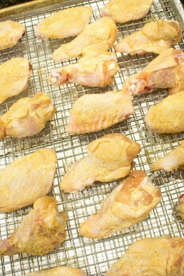 Chicken on baking rack coated with baking powder and spices.