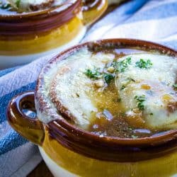 Classic French Onion Soup recipe is made with perfectly caramelized onions, toasted french bread and two kinds of melted cheese on top!